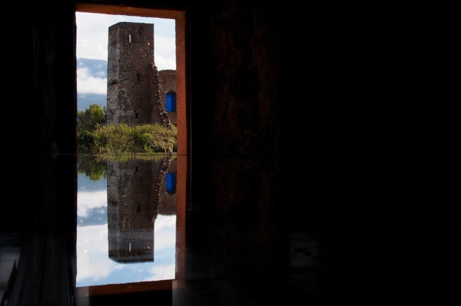 Reflection in a glass case of one of the towers at the Messner Mountain Museum.
