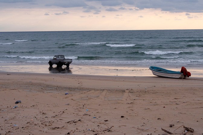 Towing the boat down to the water.