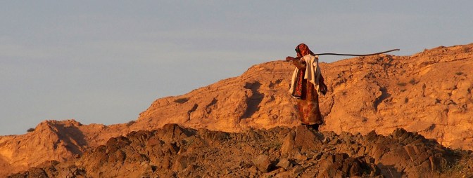 A goat herder looking out for her flock.