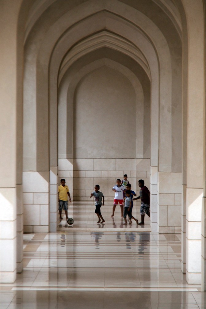 Kids playing football in one of the walkways at the Royal Palace in Muscat.