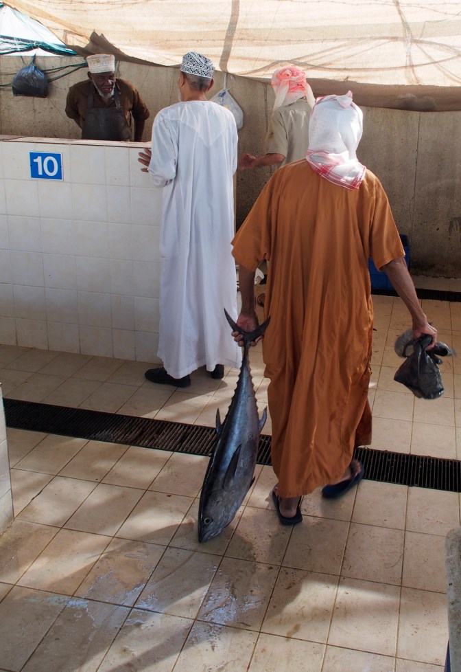 Taking a fish to the butcher block to be cut up.