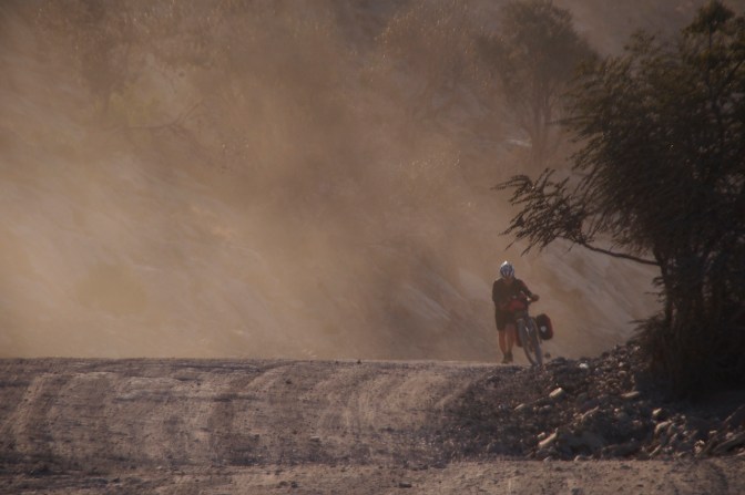 Sebastian in the dust from a vehicle on a steep section of road up Jabal Shams.