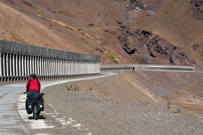Cycling on the old road past the snow sheds through which the new road runs.