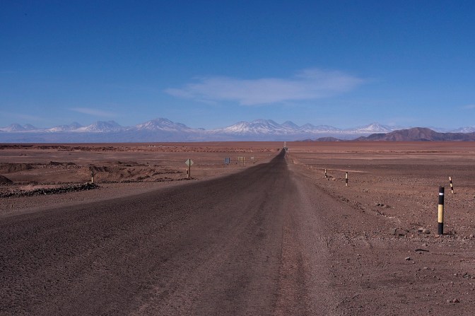 The road looks like it goes down but it's perfectly flat across the Salar De Atacama.